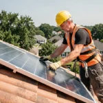 Technicien installant un panneau solaire sur un toit en tuiles avec harnais de sécurité