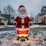 Père Noël décoratif solaire illuminé dans un jardin extérieur enneigé en hiver