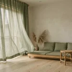 Rideaux japonisants en lin sauge dans un salon minimaliste wabi-sabi aux tons naturels